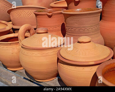 Orange und Rot ton handgefertigten Tonwaren auf die alten hölzernen Schreibtisch im Freien, traditionelle ukrainische Handwerk Stockfoto