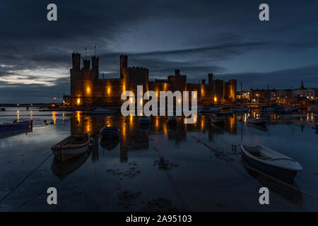 Caernarfon Castle mit Reflexionen in der Dämmerung an der Küste von Nordwales Stockfoto