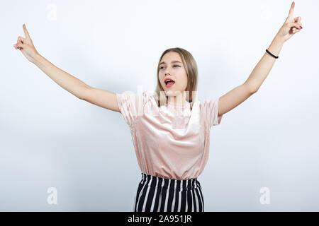 Portrait von Angst Frau in Pastell shirt warten, halten Sie die Finger nach oben Stockfoto