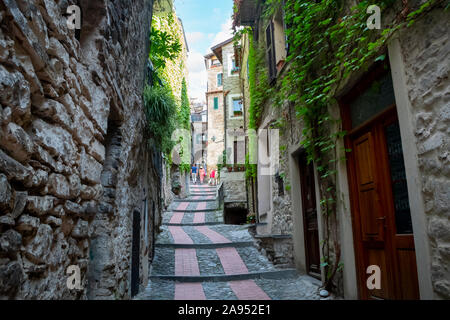 Touristen mit einem jungen Paar, gehen Sie die schmale Straße Pfad in der mittelalterlichen Dolceacqua, Italien Stockfoto
