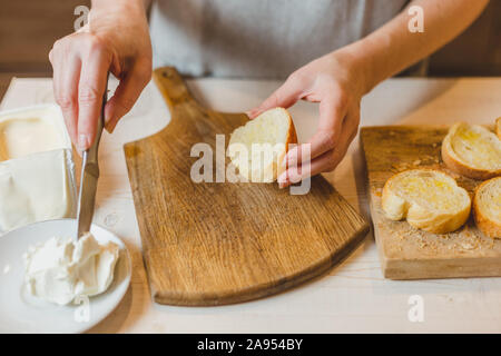 Nahaufnahme der Hausfrau braten baguette Stücke in einer Pfanne - kalte Snacks - Tapas und Sandwiches Stockfoto