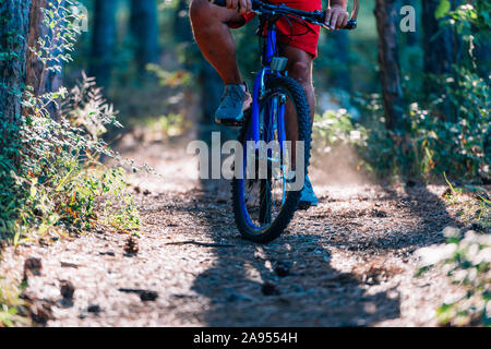 Älteren übergewichtigen Mann, Fahrten mit dem Mountainbike durch die Wälder mit extremen Aufwand. Stockfoto