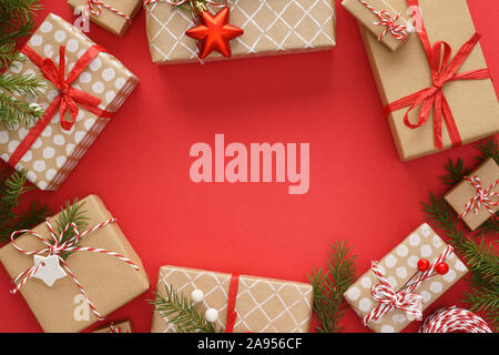 Weihnachten Rahmen aus Geschenkboxen, Spielzeug und Dekoration auf roten Hintergrund. Xmas-Vorbereitung. Flach mit kopieren. Stockfoto