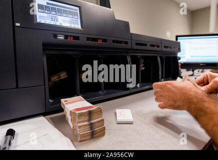 Banknoten gestapelt und zusammen mit Währung Bands vor der elektronischen Zählmaschine gebunden Stockfoto