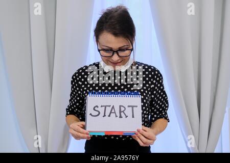Reife Frau mit Notizblock mit Hand geschrieben Word starten. Stockfoto