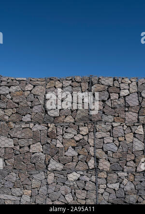 Große gabione Wand Detail an einem sonnigen Tag gegen einen klaren blauen Himmel Stockfoto