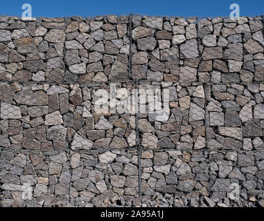 Große gabione Wand Detail an einem sonnigen Tag gegen einen klaren blauen Himmel Stockfoto