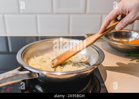 Scheiben geschnittenen Zwiebeln in einer Pfanne in heißem Öl - close-up - Home Cooking Stockfoto