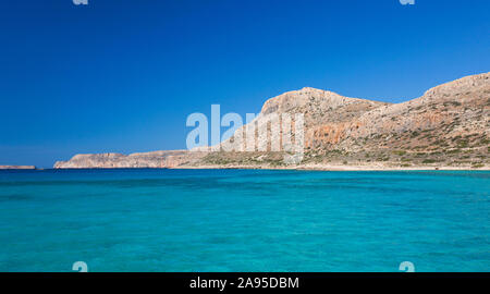 Balos, Chania, Kreta, Griechenland. Blick über das klare türkisfarbene Wasser der Gramvousa Bay auf die Halbinsel Gramvousa. Stockfoto
