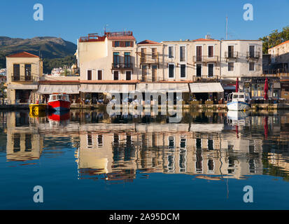 Rethymno, Kreta, Griechenland. Blick über den venezianischen Hafen, am frühen Morgen, Gebäude spiegeln sich in stillem Wasser. Stockfoto