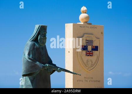 Preveli, Rethymno, Kreta, Griechenland. Kriegsdenkmal mit der Figur eines bewaffneten Mönchs in der Nähe des Oberen Preveli Klosters. Stockfoto