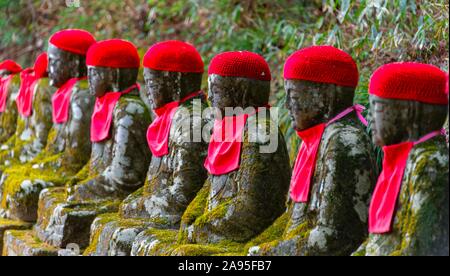 Jizo Statuen mit roten Kappen, schützenden Gottheiten für verstorbene Kinder, Kanmangafuchi Abgrund, Nikko, Japan Stockfoto