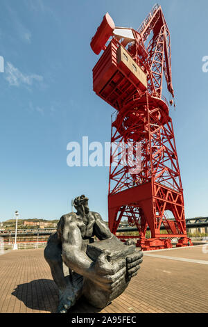 Hombre Tuercebarras (bar biegen Mann) Skulptur vor der wiederhergestellten roten La Grúa Carola (Carola Kran), Bilbao, Spanien Stockfoto