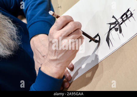 Kalligraphie Meister Zeichnung chinesische Hieroglyphe mit einer Bürste Stockfoto