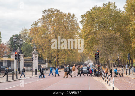 Fußgänger Constitution Hill Road, außerhalb der Buckingham Palace in London, als Verkehr hält an der roten Ampel Signal. Stockfoto