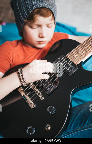 Nahaufnahme einer Rothaarigen stilvolle Junge spielt blues rock auf einem schwarzen E-Gitarre Stockfoto