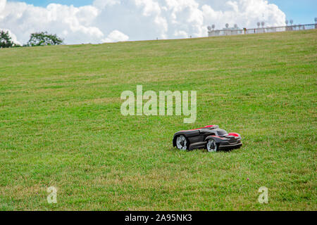 Roboter Rasenmäher auf Gras, Seitenansicht. Garten moderne remote Technologie. Nahaufnahme der Rasenmäher auf dem Feld. Stockfoto