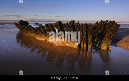 Schiffswrack an Berrow in Burnham-on-Sea Strand bei Ebbe kurz nach Sonnenaufgang auf einem klaren klaren Wintertag. Stockfoto