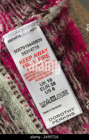 Label in Dorothy Perkins Jumper in Kambodscha gemacht - nicht in der Nähe von Feuer in verschiedenen Sprachen Stockfoto
