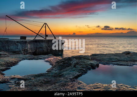 Portland Bill Dorset England schön gefärbte Sunrise zeigt die alte Derrick in Portland Bill, Teil der Jurassic Coast in Dorset. Stockfoto