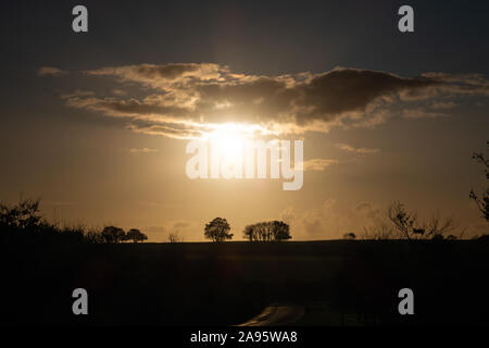 Den Sonnenuntergang über die Felder nach Bodmin Moor in der Nähe von Stoke Climsland, Cornwall, England. Stockfoto