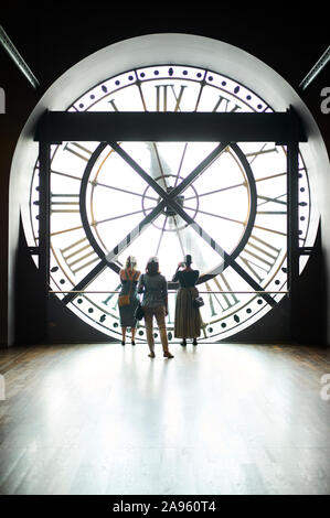 Frauen stehen vor der Uhr im Musée d'Orsay in Paris, Frankreich Stockfoto