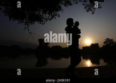 November 13, 2019, Bhaktapur, Nepal: ein Mann und ein Kind silhouetted Spaziergang um Kamal Binayak Teich in Bhaktapur, Nepal am Mittwoch, 13. November 2019. (Bild: © skanda Gautam/ZUMA Draht) Stockfoto