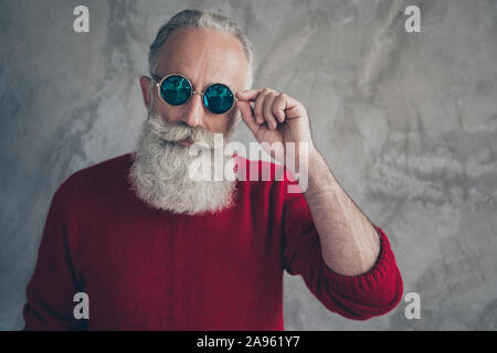 Nahaufnahme Foto von eleganten beeindruckenden alten Mann modernen Touch die Brille modische rote Pullover über graue Betonwand Farbe isoliert Verschleiß Stockfoto