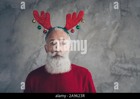 Portrait von stilvollen lustige alte Mann in deer Stirnband genießen Weihnachtsfeier masquerade tragen moderne Pullover über graue Farbe Hintergrund isoliert Stockfoto