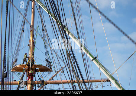 Die crossjack Yard abgesenkt wird mit dem Kran aus dem mizzenmast auf der Viktorianischen Schlachtschiff HMS Warrior, in Portsmouth Historic Dockyard, die Schiffe Masten und Teil von Ihr bugspriet vertäut sind für die grundlegenden Restaurierung in Portsmouth entfernt werden. Stockfoto