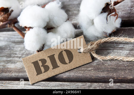 Baumwolle, Wolle und Bio Label gegen Holz- Hintergrund Stockfoto