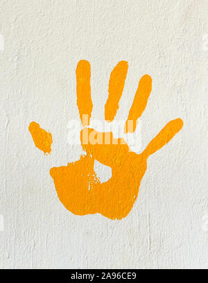 Orange Handabdruck auf eine Wand Stockfoto