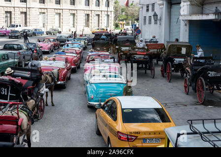 Eine Flotte von American Classic Cars, Pferdewagen und ein gelbes Taxi in die Stadt, Warten auf Kreuzfahrtschiff Fluggäste am Terminal Sierra Maestra ne Stockfoto