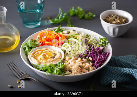 Veggie couscous Mittagessen Schüssel mit spiralazed Karotten und Zucchini, Hummus und Rotkohl Stockfoto