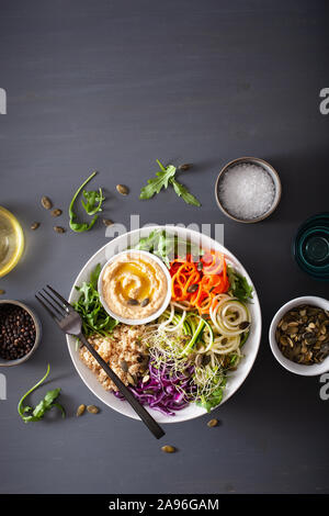 Veggie couscous Mittagessen Schüssel mit spiralazed Karotten und Zucchini, Hummus und Rotkohl Stockfoto