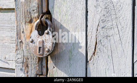 Antike Schloss auf einer hölzernen Tür. Metall vintage sperren. Rostige alte Tür verriegeln. Stockfoto