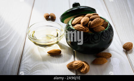Mandelöl und Mandel Muttern auf eine weiße Holztisch Stockfoto