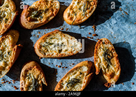 Knoblauch Parmesan Brotscheiben auf Backpapier Blatt mit Backblech. Frisch gebacken. Organisch gesunden Snacks. Stockfoto