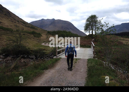 Einsame Menschen auf dem Weg zur Holzbrücke über den Fluss "Allt Ceitlein" in Glen Ceitlein in Richtung Ben Starav, Glen Etive, Scottish Highlands, Schottland, Großbritannien. Stockfoto