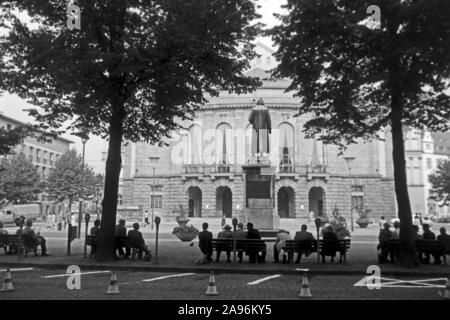 Mainzer in Artikel Bänken auf dem Gutenbergplatz und blicken in das Gutenbergdenkmal und das Stadttheater in Mainz, Deutschland 1961. Bewohner von Mainz sitzen auf Bänken am Gutenbergplatz Square, mit Blick auf die Rückseite des Gutenberg Monument und dem Stadttheater, Deutschland 1961. Stockfoto