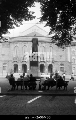 Mainzer in Artikel Bänken auf dem Gutenbergplatz und blicken in das Gutenbergdenkmal und das Stadttheater in Mainz, Deutschland 1961. Bewohner von Mainz sitzen auf Bänken am Gutenbergplatz Square, mit Blick auf die Rückseite des Gutenberg Monument und dem Stadttheater, Deutschland 1961. Stockfoto