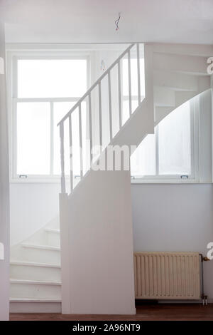 Alte Treppe in eine weiße Halle mit Fenster Licht und grunge Zentralheizung Stockfoto