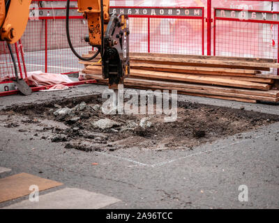 Moskau, Russland - 14. September 2019: Ein Bagger mit hydraulischen Meißel entfernt Asphalt. Fahrbahn. Not arbeiten. Um eine Marke mes Stockfoto