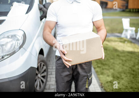 Delivery Man Holding carboard Paket im Freien, in der Nähe auf dem Feld mit Leerzeichen Stockfoto