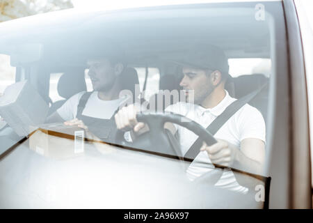 Freundliche Lieferung Unternehmen Mitarbeiter fahren eine Ladung Fahrzeug, Lieferung von einem Auto, Blick durch die Windschutzscheibe Stockfoto
