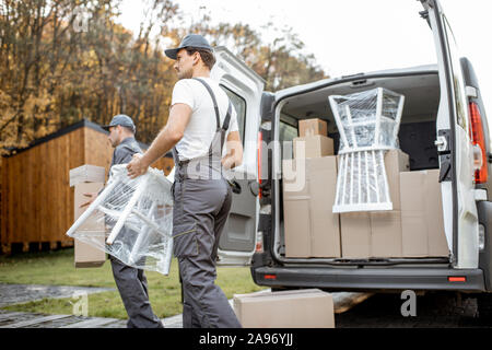 Lieferung Unternehmen Mitarbeiter abladen Cargo van Fahrzeug, liefern einige Güter und Möbel zu einem Kunden Startseite. Umzug und professionelle Lieferung Konzept Stockfoto