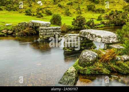 Beschädigte Clapper Bridge bei Bellever über den East Dart River am Dartmoor in Devon an einem übergiebelten Tag Stockfoto