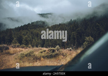 Auf der Suche über die Motorhaube eines Land Rover als ein Berg ist im Nebel. Stockfoto