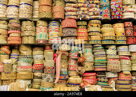 Asiatische und Indische Kleidung Verkleidungen und Kleid Grenzen in Gold und Brokat mit bunten stitching Detail auf Anzeige Stockfoto