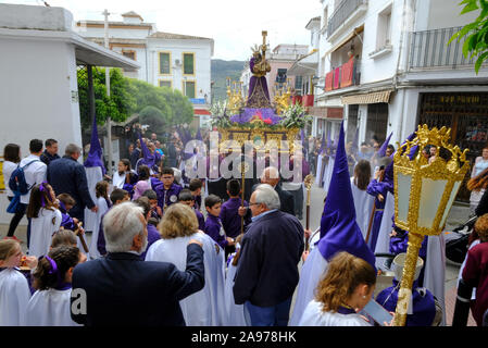 Prozession der lokalen Gemeinschaft tragen lila capirotes, tragen Jesus und das Kreuz während der Karwoche. Carcabuey, Provinz Cordoba, Andalusien. Spanien Stockfoto